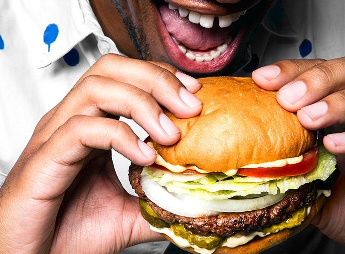 Man eating an Impossible Burger